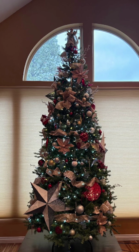 A full-height tree styled with a rustic barn star, burlap and gold ribbon